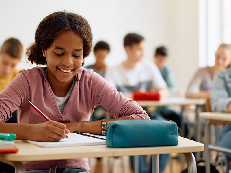 Young girl writing in notebook at desk