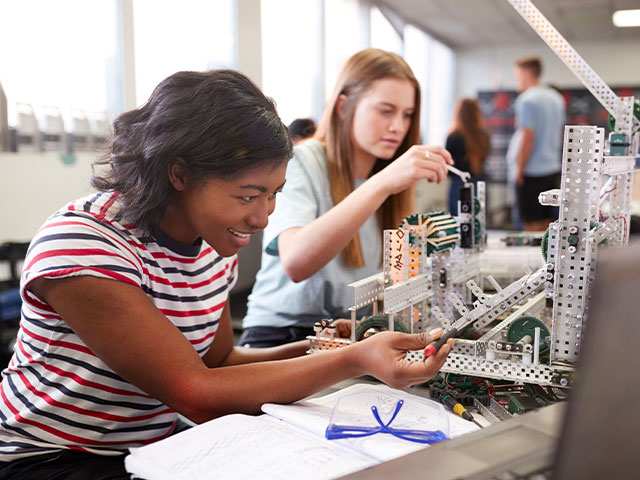 Two female high school students working on engineering project