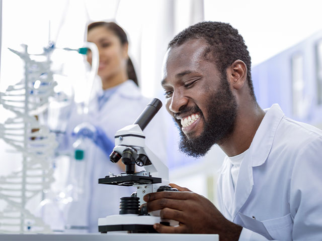 Scientist examining sample with microscope